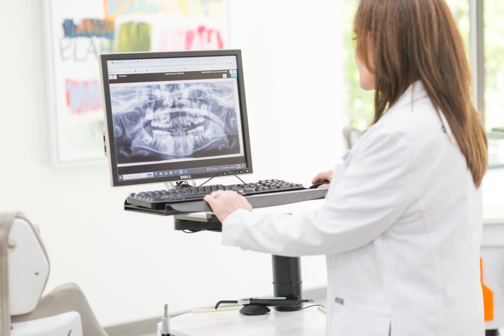 Dr. Sherri Weissman, board-certified orthodontist in Birmingham AL, reviewing a patient's digital X-ray during a first visit exam